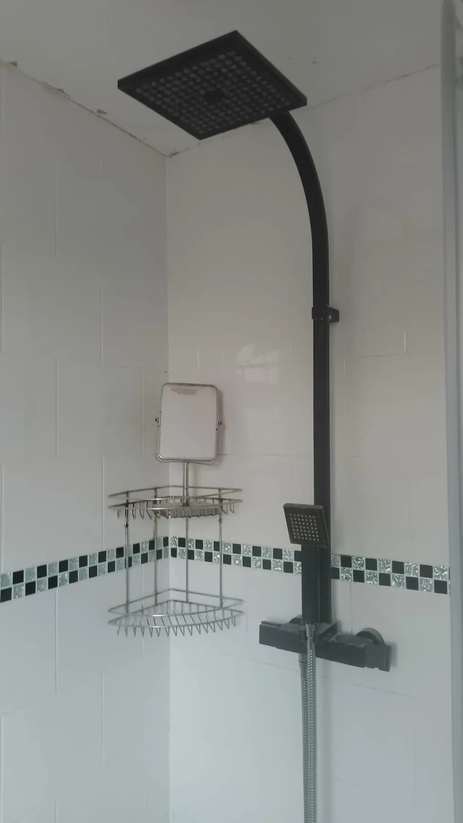 Dated black square rainfall shower with matte black riser before replacement in an Earlsdon Coventry bathroom