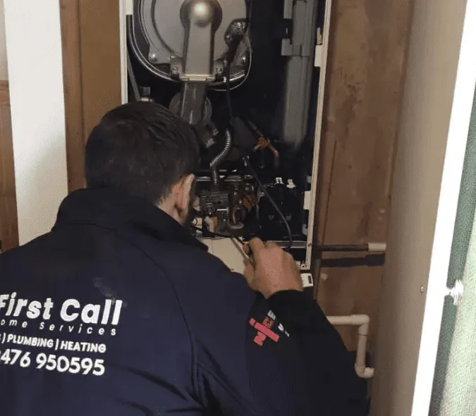 First Call Home Services engineer inspecting a wall-mounted boiler